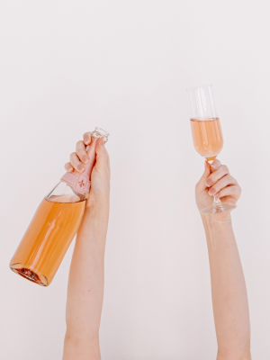 Person Holding a Bottle of Champagne and Flute