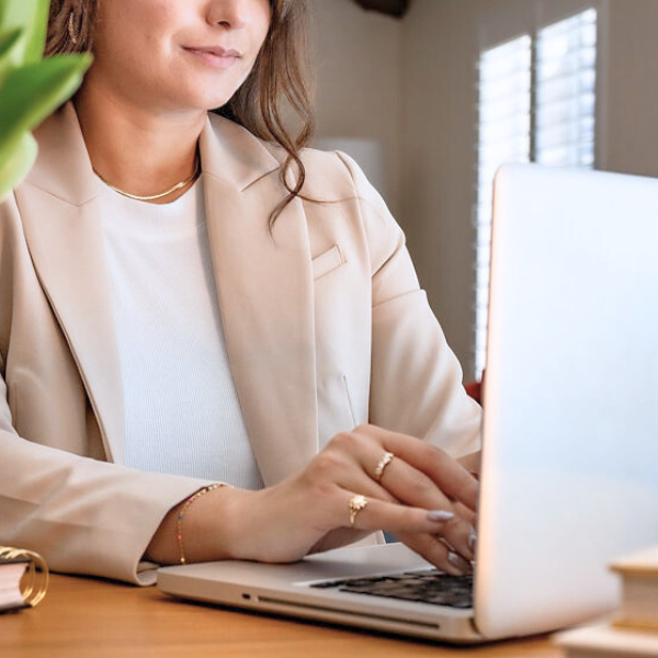 woman working on SEO services wearing a beige coat
