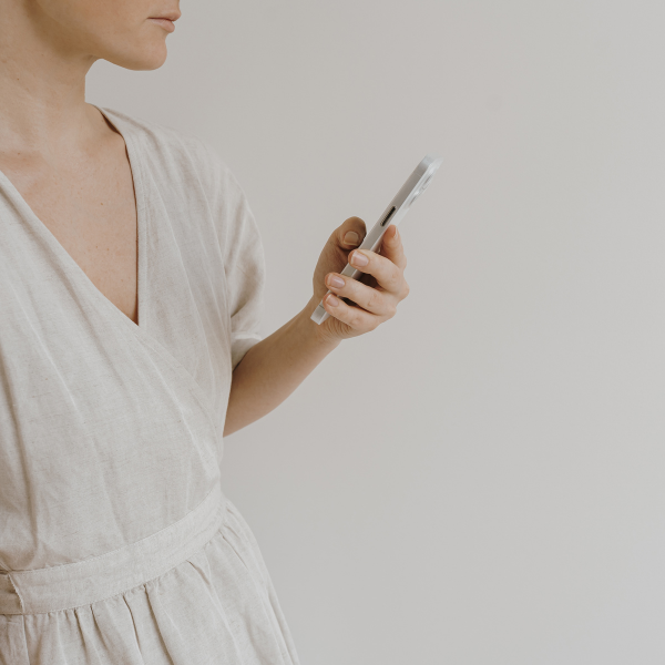 woman holding phone looking at social media