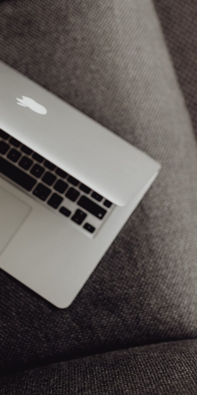 A closed laptop resting on a grey armchair, representing the task of checking a website to see if it is blocking AI crawlers.
