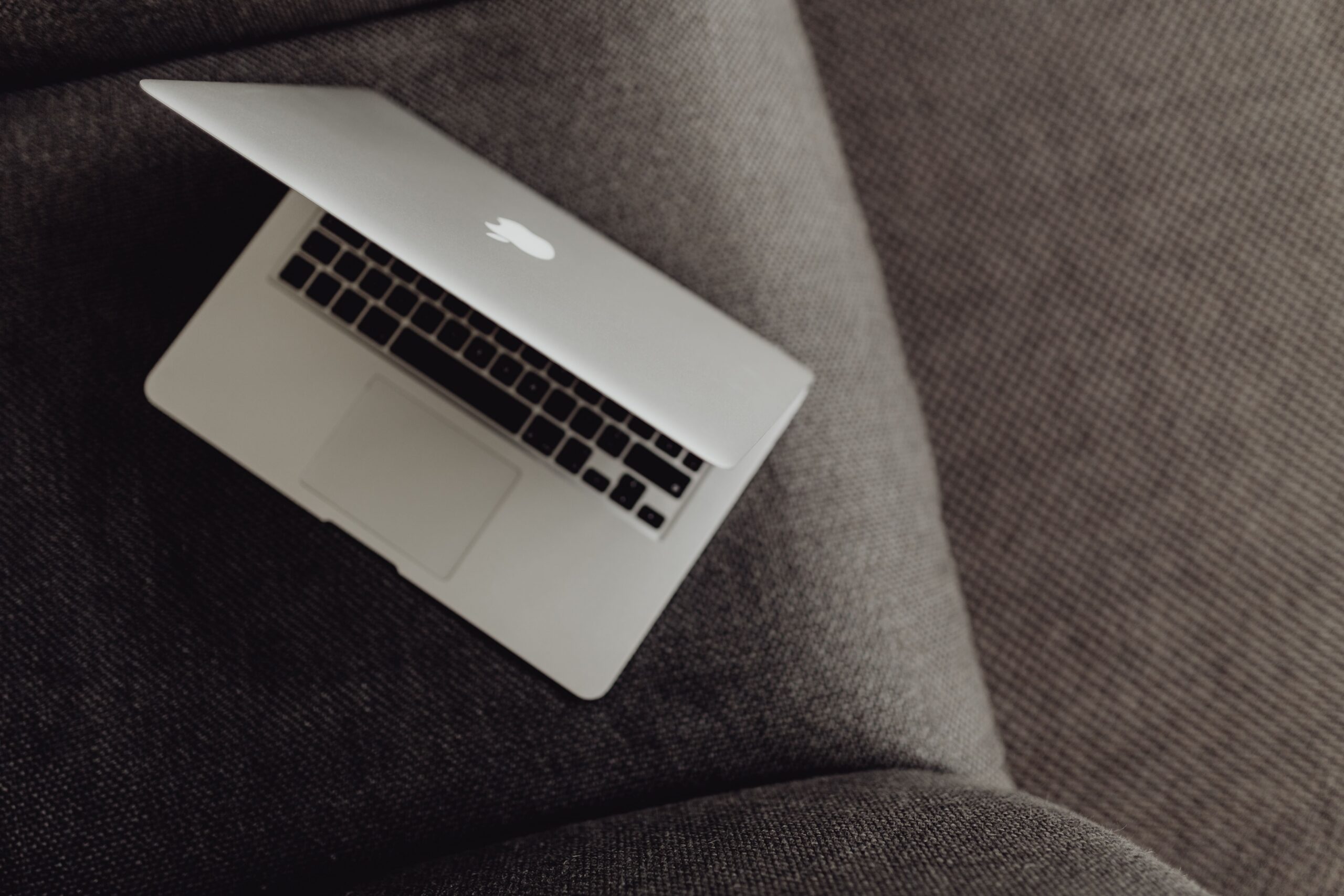 A closed laptop resting on a grey armchair, representing the task of checking a website to see if it is blocking AI crawlers.