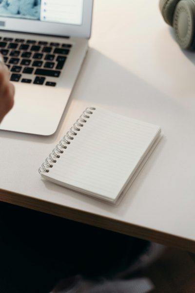 white notepad next to a laptop